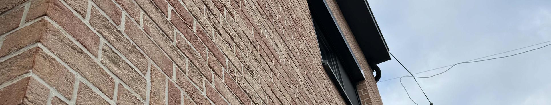 Gevelisolatie met een afwerking van steenstrips en crepi te Rumst