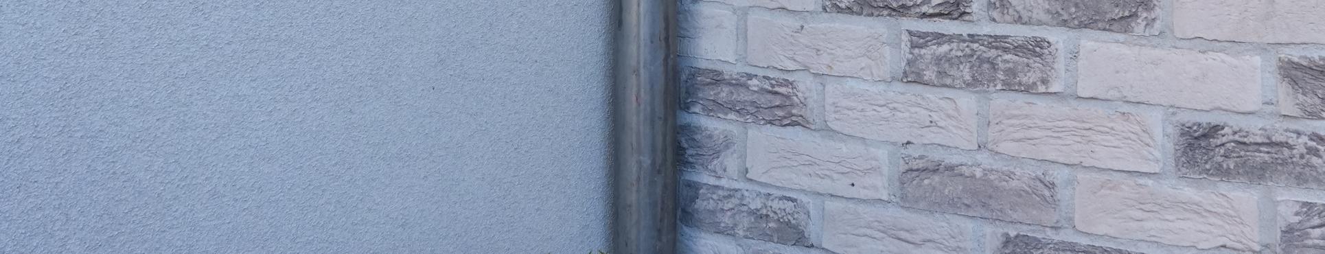 Gesloten woning in De Klinge met spuitkurk en steenstrips.